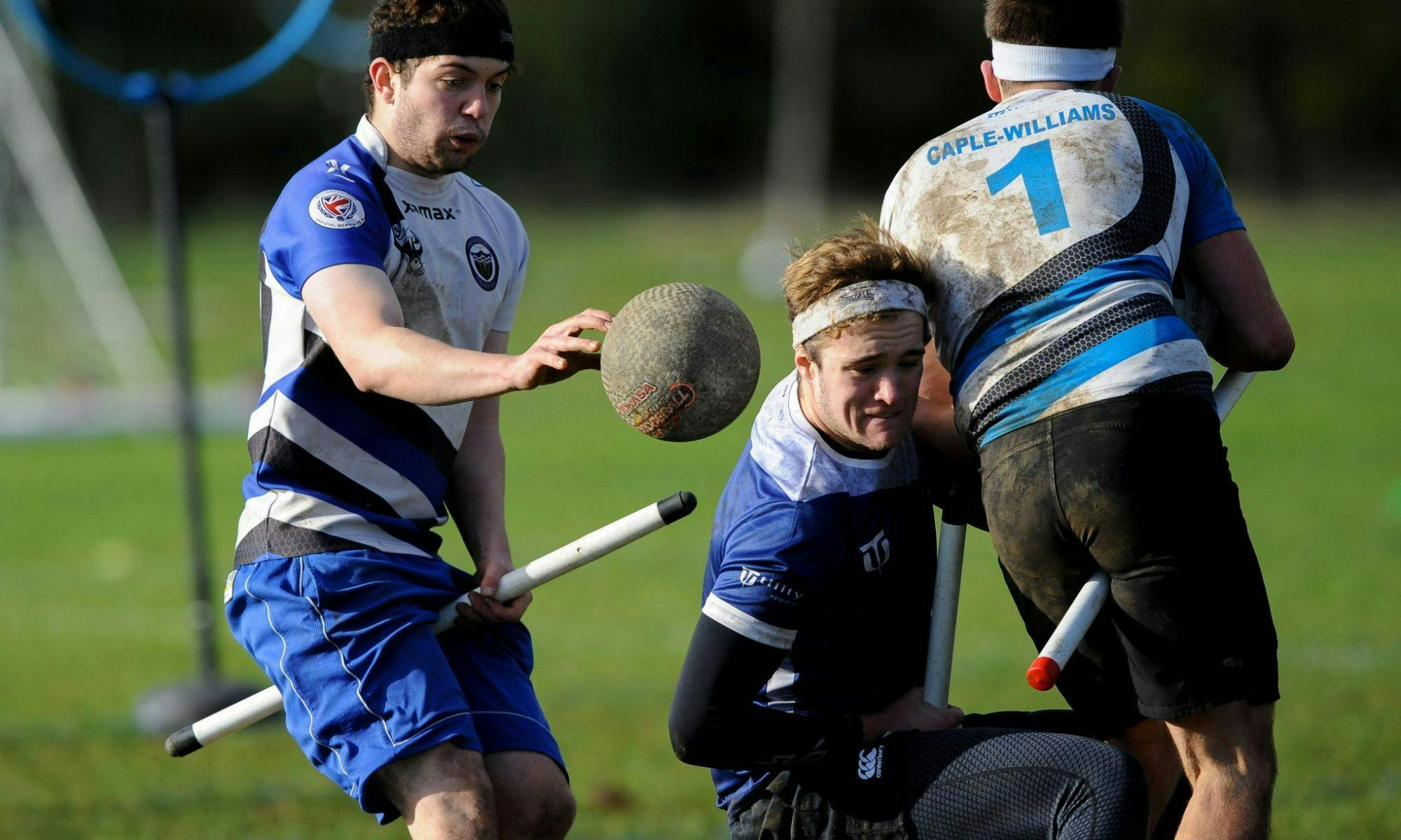 A chaser attempts to tackle a player while an opposing beater throws a bludger at them