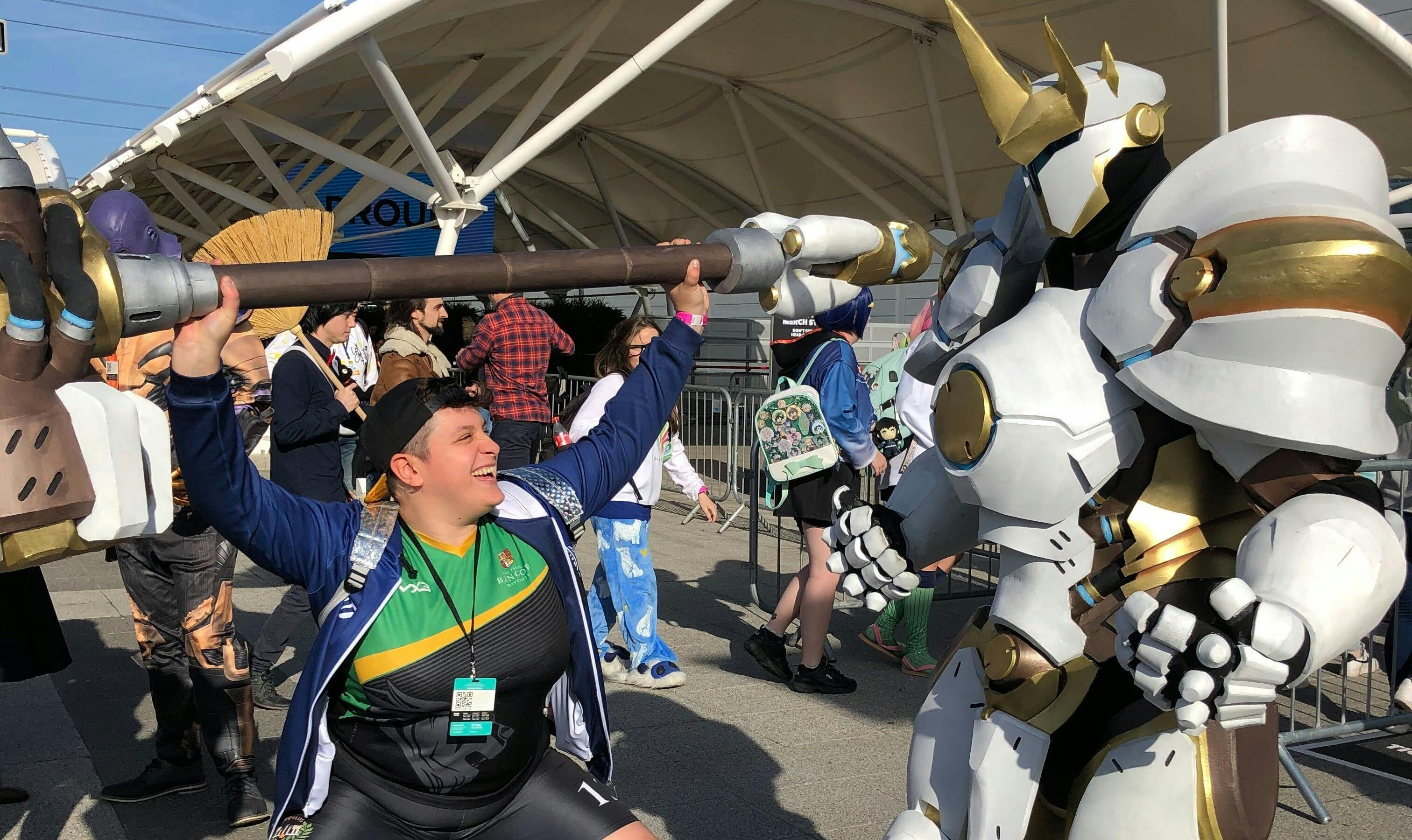 Chloe Durkin, Clubs Director, Squats outside ComicCon, facing off against someone in a white Mecha suit.