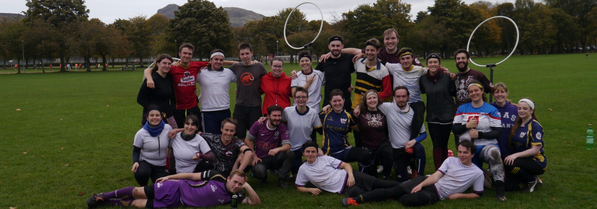 Large group of scottish quidditch players meeting up for the Scottish national team tryouts in large field.