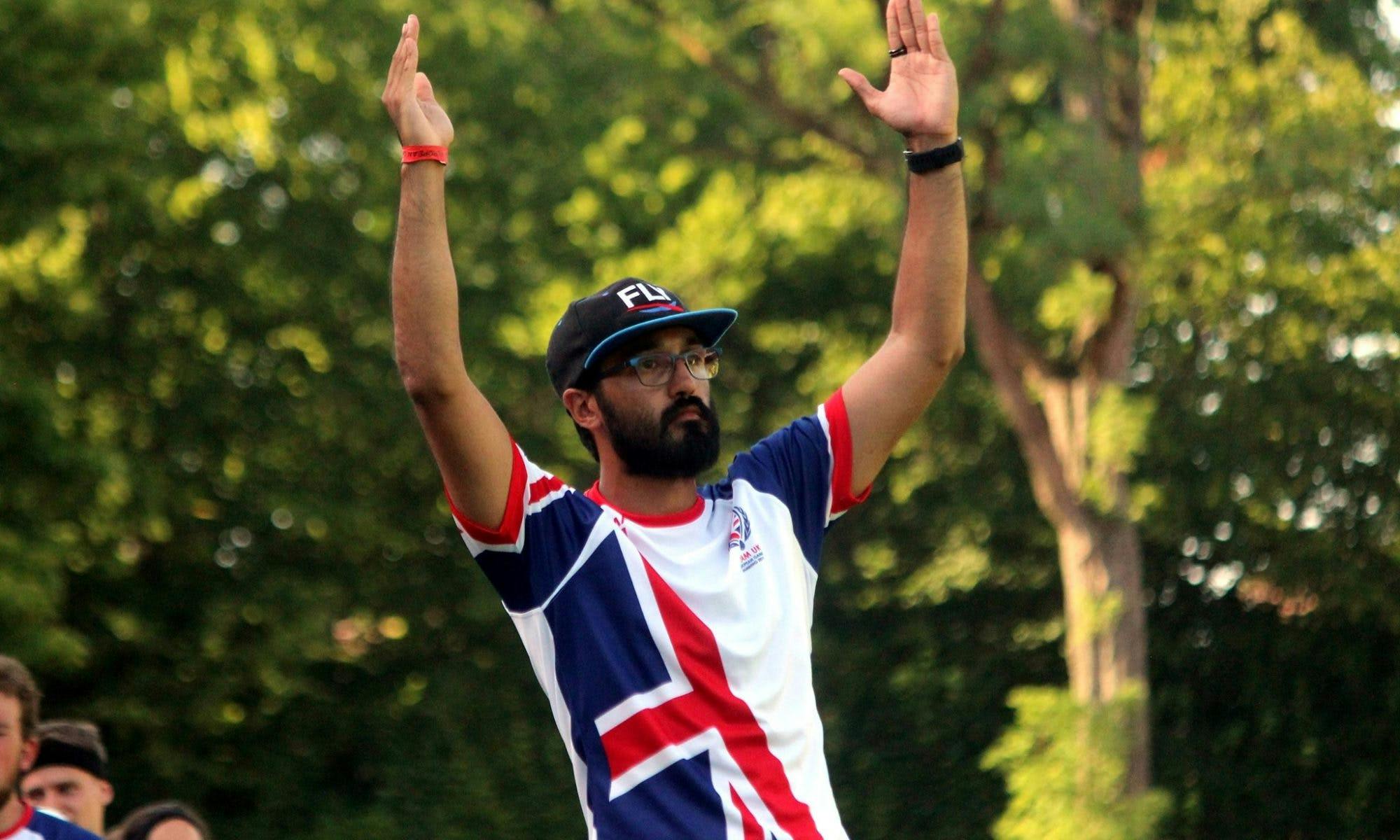 James Thanangadan stands wearing a Team UK Kit with his arms raised to indicate a goal