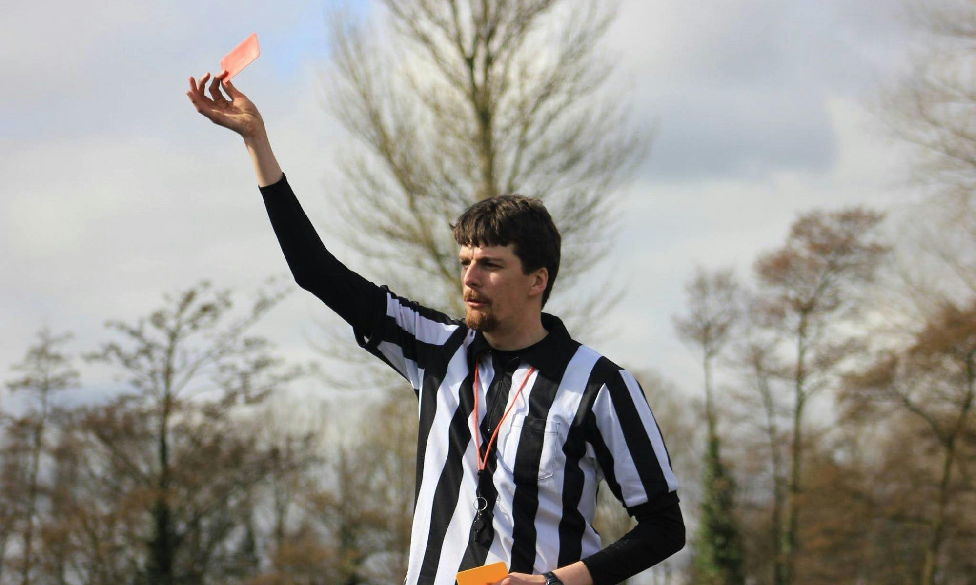 Eamonn Harrison holds a red card while refereeing a Quidditch match